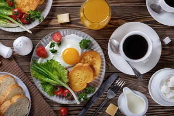 Fried eggs, croutons and salad with coffee and orange juice.