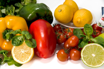 Obraz na płótnie Canvas fresh raw vegetables, salad preparation, pepper, tomatoes, cucumber, fresh salad, lime, lemon, cheese