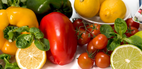 Obraz na płótnie Canvas fresh raw vegetables, salad preparation, pepper, tomatoes, cucumber, fresh salad, lime, lemon, cheese