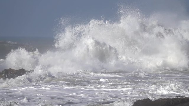Splashes from atlantic ocean big waves over cliffs, slow motion
