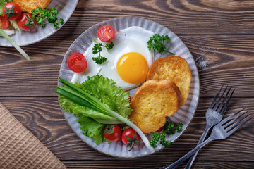 Fried eggs, croutons and salad with coffee and orange juice.