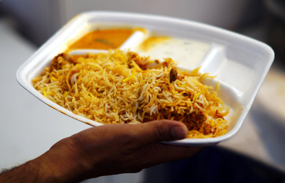 Hand holding, Indian street food Chicken Biryani or chicken fried Rice,plate