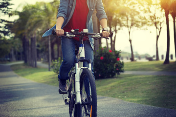 Fototapeta na wymiar woman cyclist riding bike in tropical park