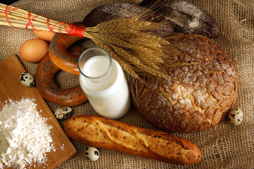 Fototapeta na wymiar Top view of the table with bread, milk, flour and eggs, preparation for breakfast in the bakery