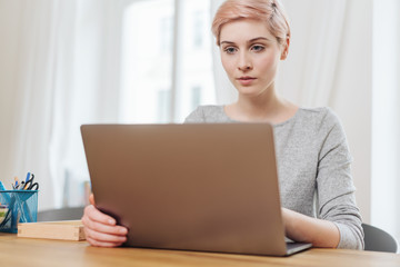 Fototapeta premium Serious young woman working on a laptop