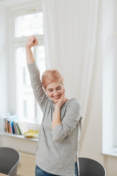Elated attractive woman gesturing with her fist
