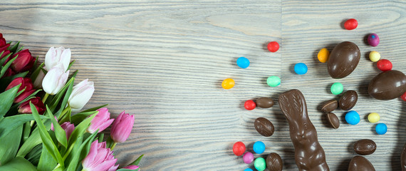 Delicious chocolate easter eggs ,bunny and sweets on dark wood background