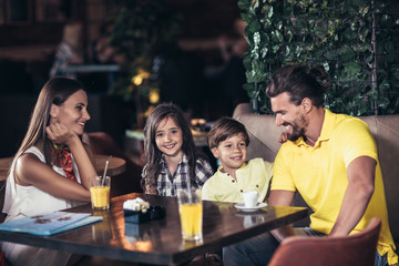 Family with two children having great time in a cafe after shopping