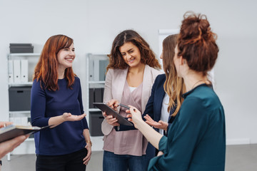 Happy college students in discussion with tablet