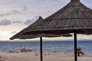 Umbrella and a bamboo sun shade in an empty paradise beach at sunny day