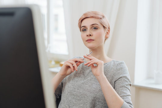 Thoughtful young woman reading on a computer