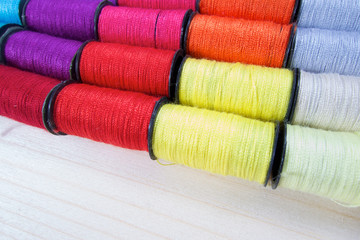 Rainbow of colourful thread spools on the table