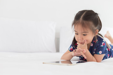 Naklejka premium Children playing tablet in bedroom with copy space