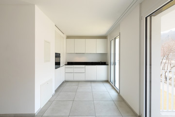 White kitchen with windows in modern apartment
