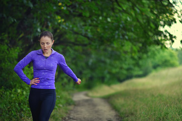 Fototapeta premium Tired young girl on a run in the forest.