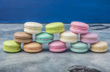 Pyramid of makarons. Colorful cookies. Cake macaron or macaroon on a blue background 1