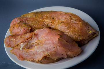 large piece of raw chicken fillet on white plate