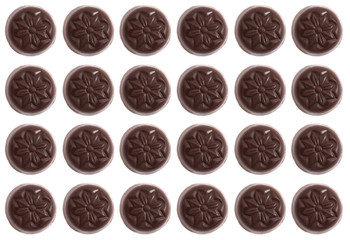Twenty-four round candies on a white background