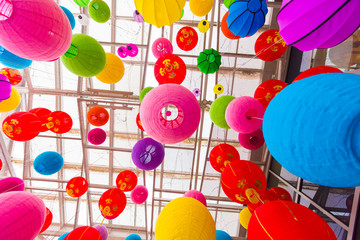 Fototapeta na wymiar Colorful folding paper lantern on the ceiling,Ceiling light Chinese New Year