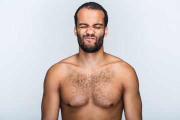 Fototapeta premium Having some doubt. Portrait of handsome shirtless young black man making face while standing against white background