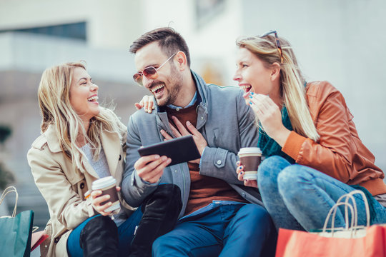 Group of smiling friends with digital tablet outdoor