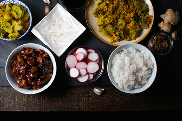Pieces of teriyaki chicken, rice vermicelli and tempura broccoli on the table top view. Asian cuisine