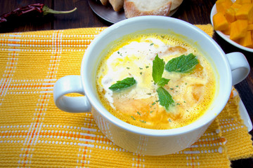 Hot pumpkin soup with green herb and homemade healthy bread