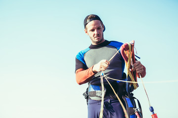Kitesurfers on the beach prepare sport equipment for riding
