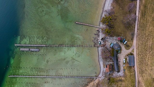 Der Tegernsee im Ausschnitt mit Steg und Ufer als Luftbild bzw. Aerial von oben als Droneshot; der berühmte See senkrecht von oben im Ausschnitt
