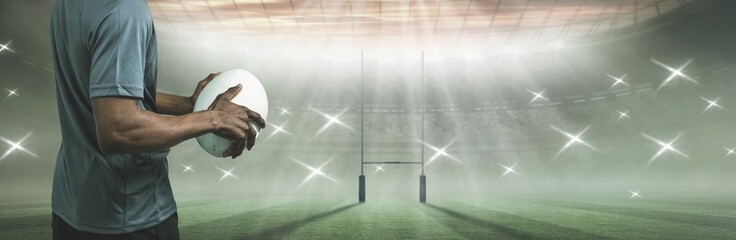 Composite image of sportsman holding rugby ball