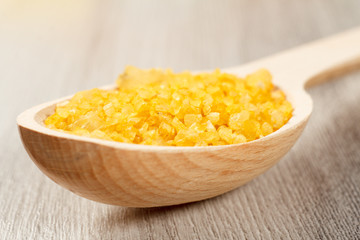 Spa nature products. Wooden spoon with yellow sea salt for bathroom procedures