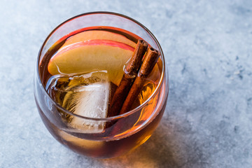 Apple Cider Whiskey Cocktail with Cinnamon Sticks, Ice and Apple Slices.