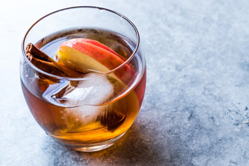 Apple Cider Whiskey Cocktail with Cinnamon Sticks, Ice and Apple Slices.