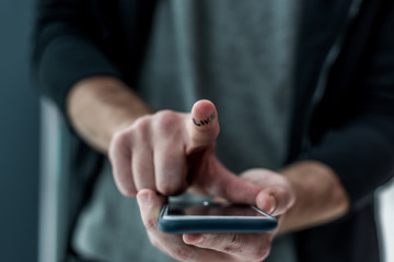 cropped shot of man touching smartphone screen with like sign on finger, phone addiction concept