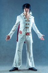 Smiling rockstar in white vintage costume in studio.