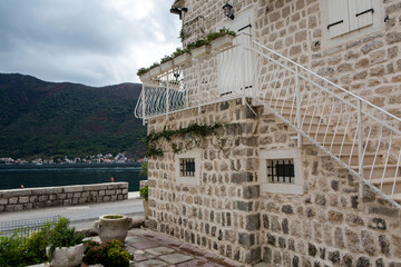 wall white stone house standing next to the promenade