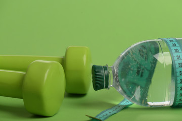 Healthy lifestyle and low calorie drink concept. Dumbbells in green