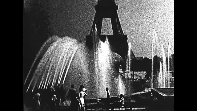 Paris Eiffel Tower with fountain from Palais de Chaillot palace. Jardins du Trocadero gardens with tourists. Historic BW archival footage from 1960 in France.