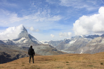 壮大なスイスの山を見る男性 - obrazy, fototapety, plakaty