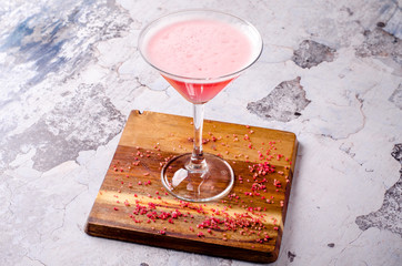 Top view red pink cocktail Cosmopolitan fresh in a martini glass on a wooden board, gray background. Bar alcohol drink menu, delicious tequila sunrise long drink.