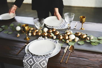 cropped image of waiter serving easter table in restaurant