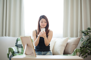 スマホ・女性・ソファ