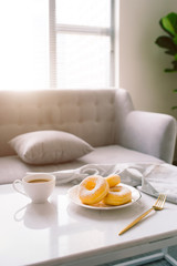 classic donut and coffee on white table.
