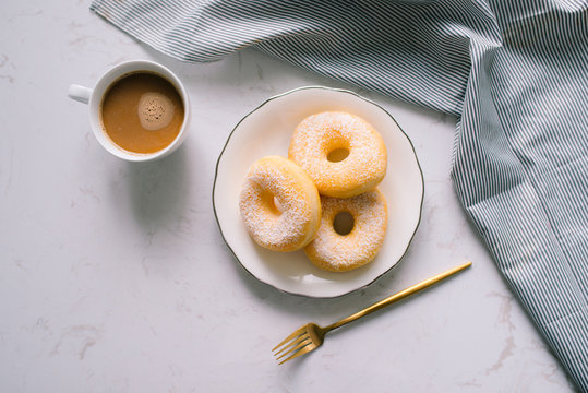 Overhead view of chocolate cake donuts with salted caramel Glaze with a cup of espresso on marble table top. Afternoon me time book reading with dessert and coffee. Text space images