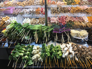 Vast selection of fresh Lok Lok street food on stand in night market in Jalan Alor area of Kuala...