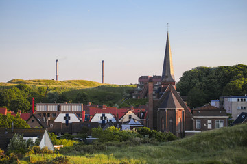 Wijk aan zee city church tower and the industrial park in the background	