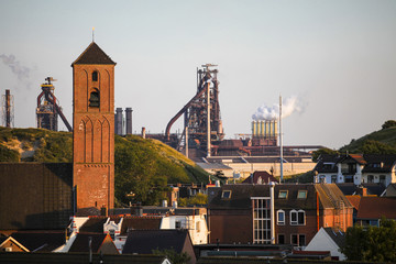 Wijk aan zee city church tower and the industrial park in the background	