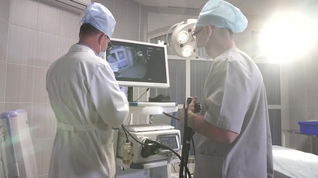 The doctor and his assistant prepare medical equipment for operation in the operating room