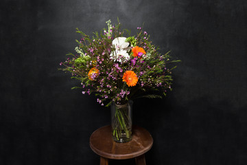 Fototapeta na wymiar flower Ikibana on a black background, bouquet in a glass vase