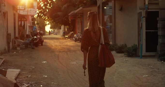 Following Shot of a Beautiful Woman in a Dress Walking Through the Streets of the Authentic Village. Scenic South Asia View. Traveling Alone. Shot on RED Epic 4K UHD Camera.